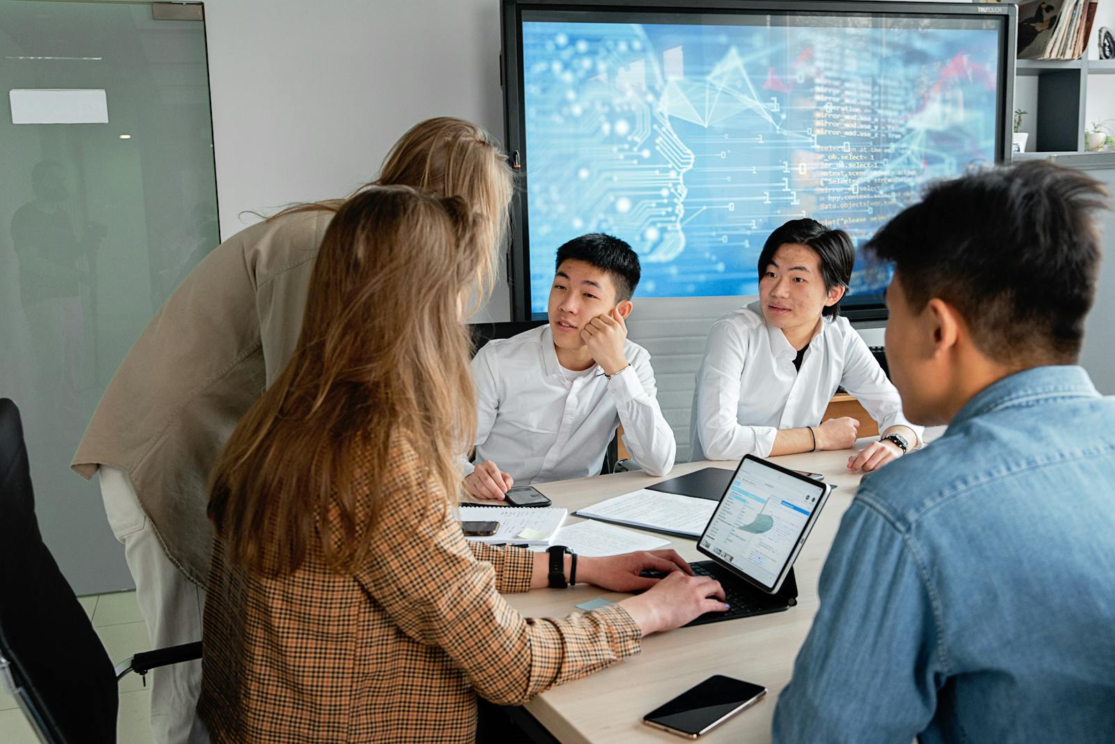 Team-Workshop mit digitaler Anzeige im Hintergrund